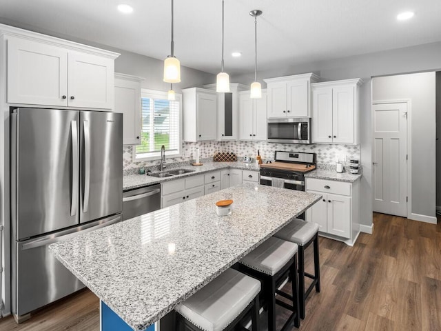 7121 208th St N, Forest Lake, MN 55025 - kitchen with stainless steel appliances, a breakfast bar, recessed lighting, a center island, and white cabinets