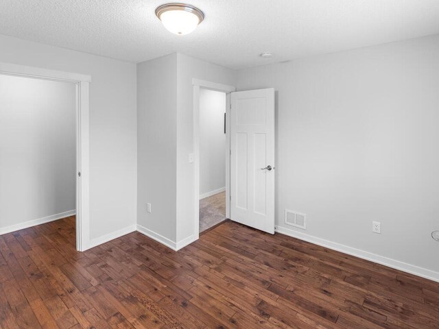 7121 208th St N, Forest Lake, MN 55025 - unfurnished bedroom with dark wood finished floors and a textured ceiling