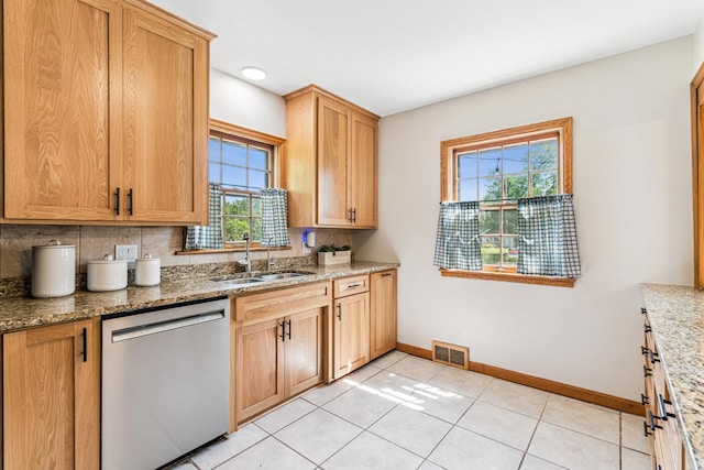 5640 13th Ave S, Minneapolis, MN 55417 - kitchen with stainless steel dishwasher, backsplash, light stone counters, and light tile patterned floors