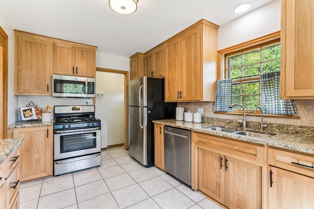 5640 13th Ave S, Minneapolis, MN 55417 - kitchen with appliances with stainless steel finishes, tasteful backsplash, light stone counters, and light tile patterned floors