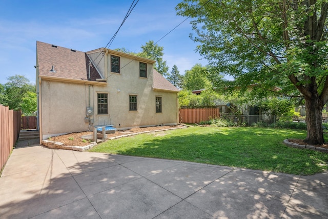 5640 13th Ave S, Minneapolis, MN 55417 - rear view of house with stucco siding, a fenced backyard, roof with shingles, and a patio