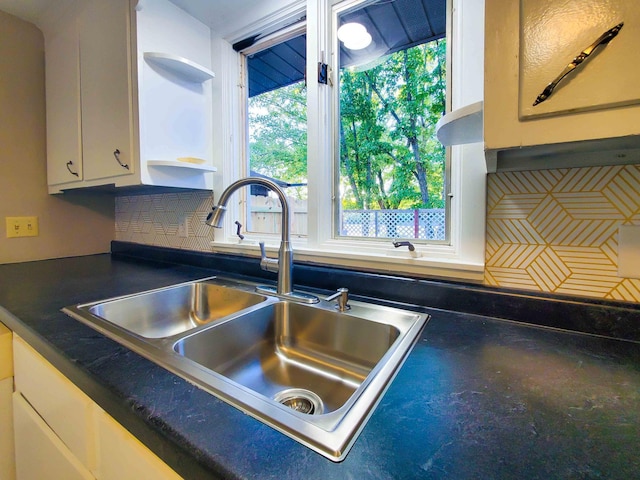 732 Vernon Ave NW, Elk River, MN 55330 - kitchen view of a sink, backsplash, dark countertops, open shelves, and white cabinetry