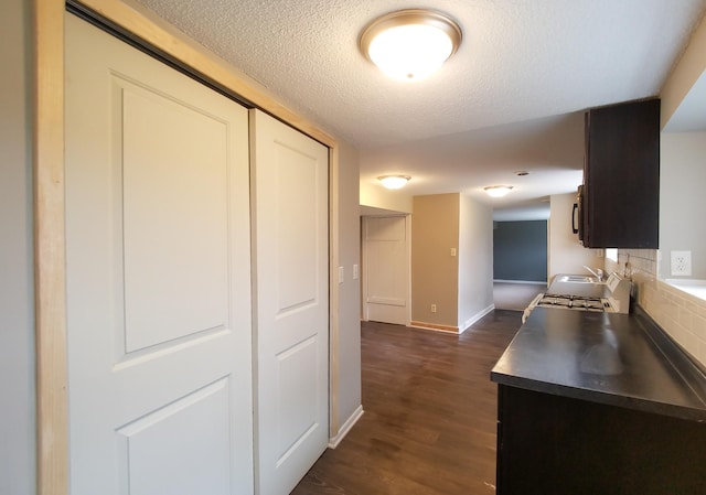 732 Vernon Ave NW, Elk River, MN 55330 - kitchen featuring dark wood-type flooring, range with gas stovetop, baseboards, a textured ceiling, and a sink