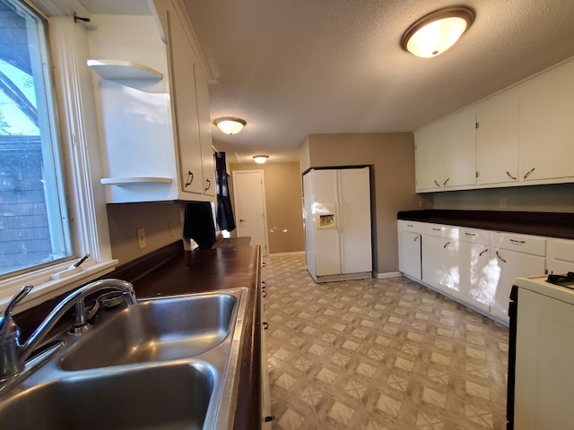 732 Vernon Ave NW, Elk River, MN 55330 - kitchen with white fridge with ice dispenser, a sink, light flooring, range, and white cabinetry