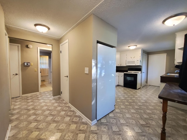 732 Vernon Ave NW, Elk River, MN 55330 - kitchen featuring gas range oven, white microwave, light floors, white cabinetry, and a textured ceiling