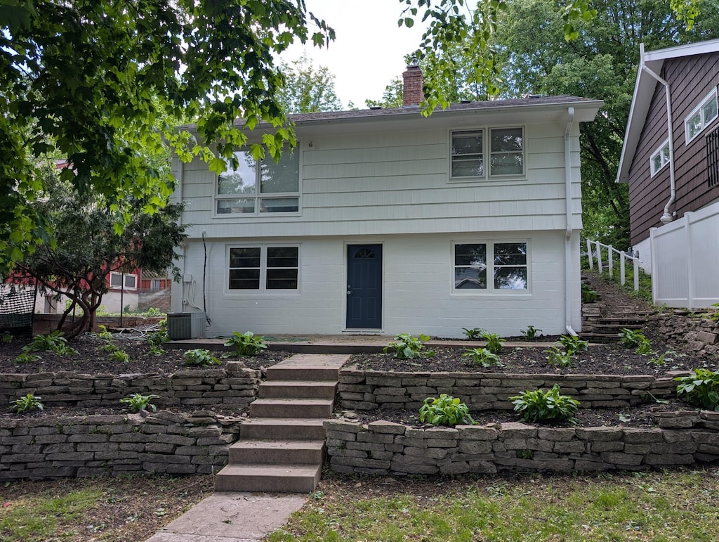 4825 Drew Ave S, Minneapolis, MN 55410 - colonial-style house with a chimney, stairway, and central AC unit