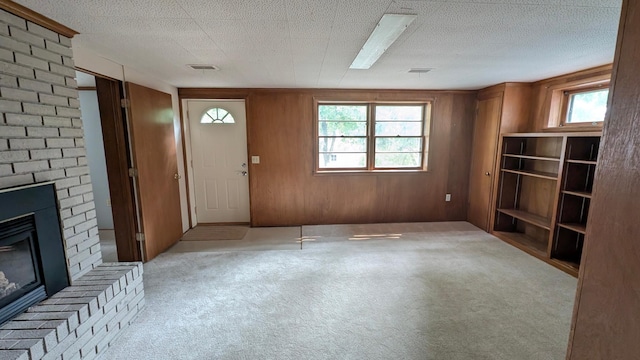 4825 Drew Ave S, Minneapolis, MN 55410 - unfurnished living room featuring light carpet, a brick fireplace, and wooden walls