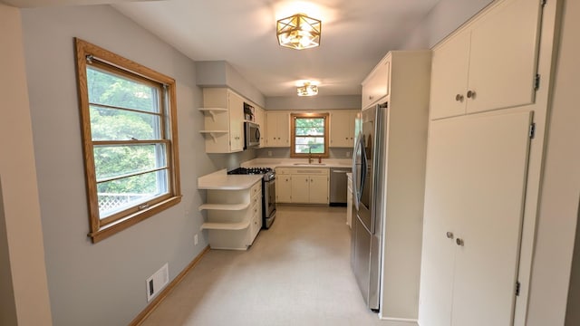 4825 Drew Ave S, Minneapolis, MN 55410 - kitchen featuring stainless steel appliances, open shelves, a sink, light countertops, and baseboards