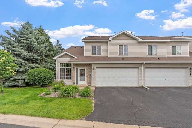 1297 124th Ave NE, Blaine, MN 55434 - view of property featuring asphalt driveway, a front yard, an attached garage, and a shingled roof