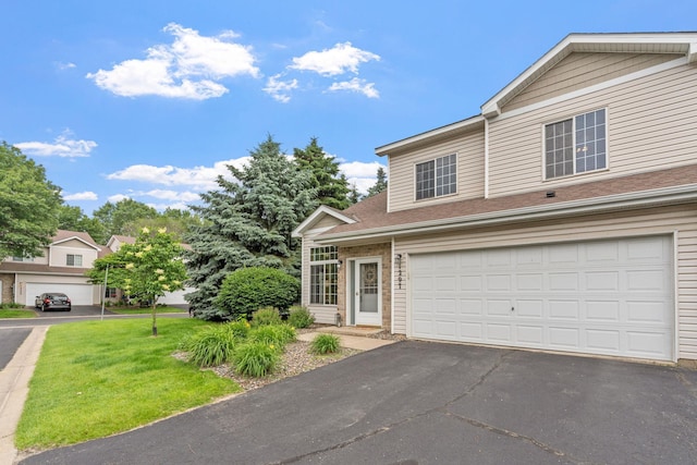 1297 124th Ave NE, Blaine, MN 55434 - traditional-style home featuring asphalt driveway, a front lawn, a shingled roof, and an attached garage