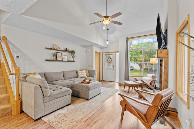 1297 124th Ave NE, Blaine, MN 55434 - living area with light wood-style flooring, ceiling fan, stairs, and vaulted ceiling