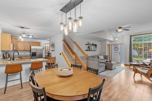 1297 124th Ave NE, Blaine, MN 55434 - dining space featuring a textured ceiling, light wood-type flooring, ceiling fan, and stairway