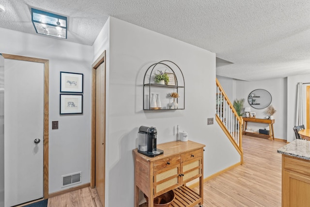 1297 124th Ave NE, Blaine, MN 55434 - foyer entrance featuring a textured ceiling, light wood finished floors, and stairs