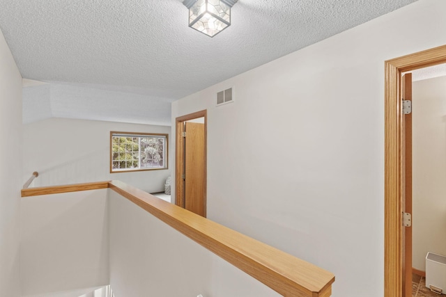 1297 124th Ave NE, Blaine, MN 55434 - corridor with a textured ceiling and an upstairs landing