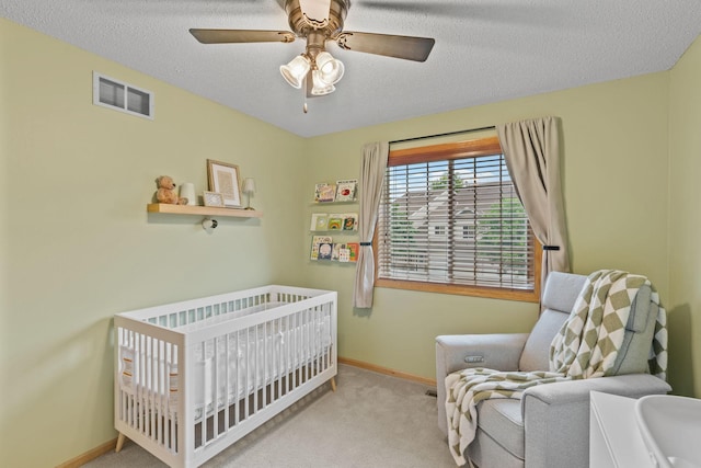 1297 124th Ave NE, Blaine, MN 55434 - carpeted bedroom with a crib, a textured ceiling, and a ceiling fan
