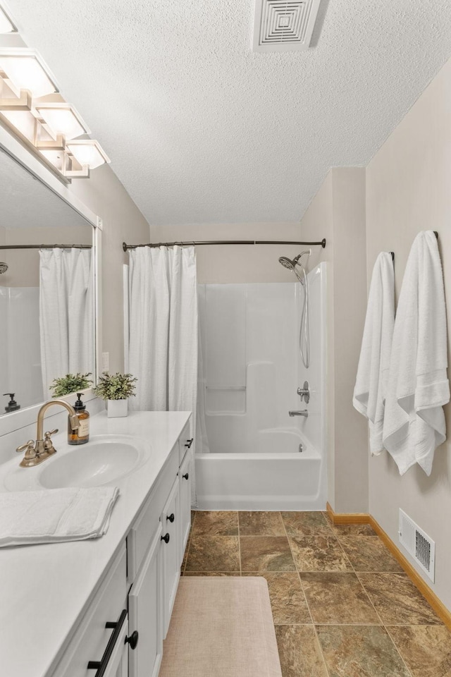 1297 124th Ave NE, Blaine, MN 55434 - full bath with vanity, shower / tub combo, a textured ceiling, and stone finish floors