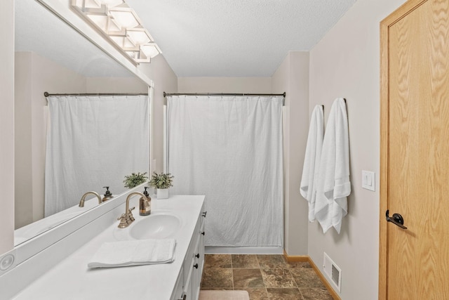 1297 124th Ave NE, Blaine, MN 55434 - full bathroom with vanity, a textured ceiling, and stone finish flooring