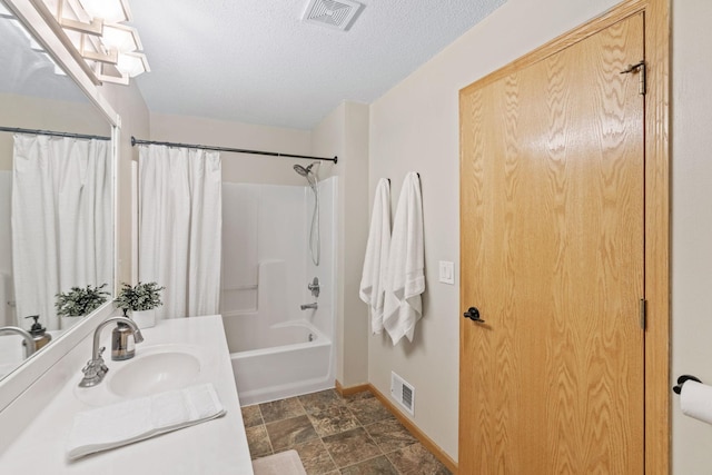 1297 124th Ave NE, Blaine, MN 55434 - bathroom featuring shower / tub combo, vanity, stone finish flooring, and a textured ceiling