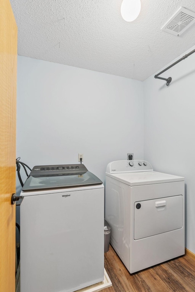 1297 124th Ave NE, Blaine, MN 55434 - laundry area with washing machine and dryer, wood finished floors, and a textured ceiling