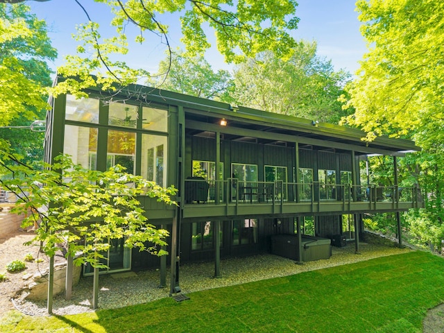 18101 Woolman Dr, Minnetonka, MN 55345 - rear view of house featuring a sunroom, a lawn, and a wooden deck