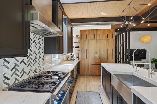 18101 Woolman Dr, Minnetonka, MN 55345 - kitchen with wall chimney range hood, stainless steel range with gas cooktop, light wood finished floors, tasteful backsplash, and light stone countertops