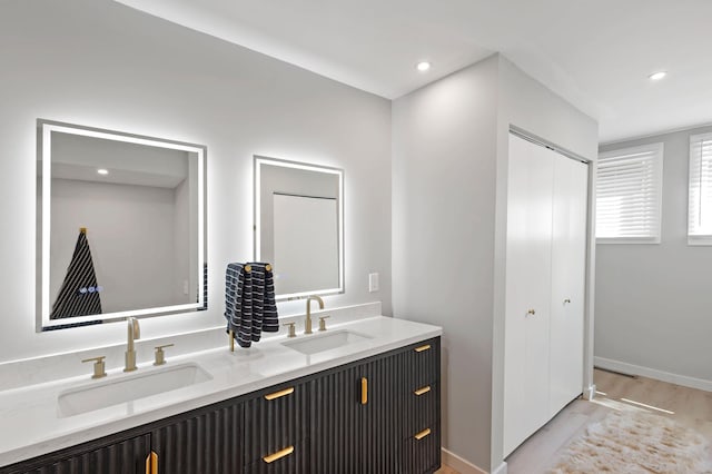 18101 Woolman Dr, Minnetonka, MN 55345 - full bathroom featuring wood finished floors, double vanity, recessed lighting, and baseboards
