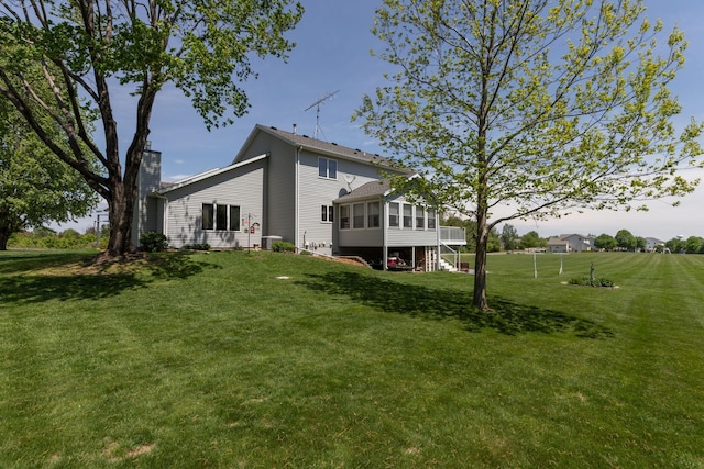 176 Westchester Dr NW, Rochester, MN 55901 - back of property with a sunroom and a lawn