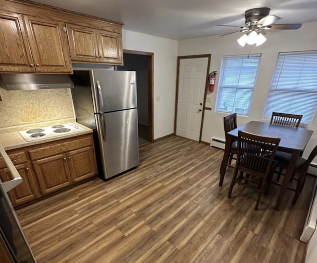 1733 37th Ave NE, Columbia Heights, MN 55421 - kitchen with under cabinet range hood, freestanding refrigerator, white electric cooktop, a ceiling fan, and wood finished floors