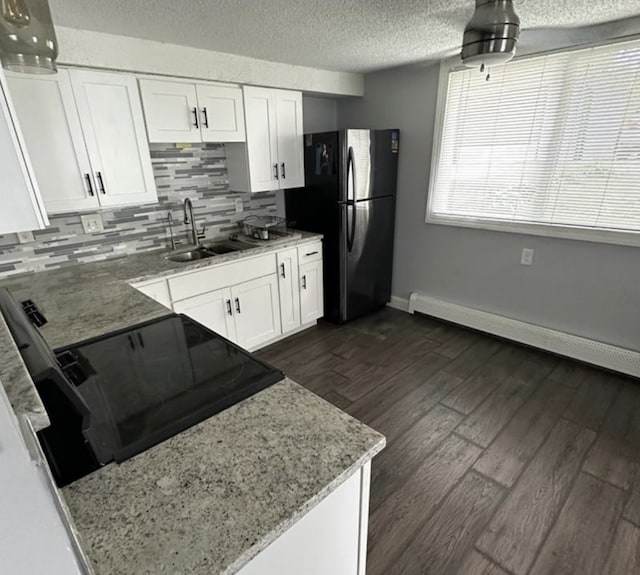 1733 37th Ave NE, Columbia Heights, MN 55421 - kitchen featuring freestanding refrigerator, white cabinets, tasteful backsplash, baseboards, and light stone countertops