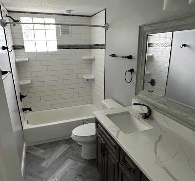 1733 37th Ave NE, Columbia Heights, MN 55421 - bathroom with toilet, vanity,  shower combination, and a textured ceiling