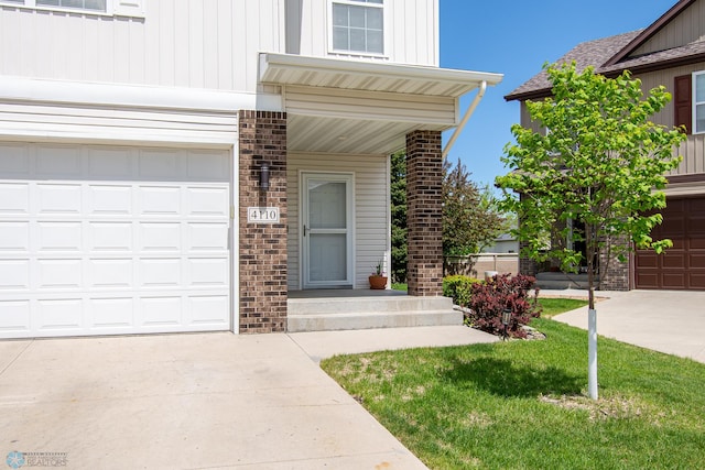 4110 Clubhouse Dr S, Fargo, ND 58104 - doorway to property with brick siding, driveway, and a garage