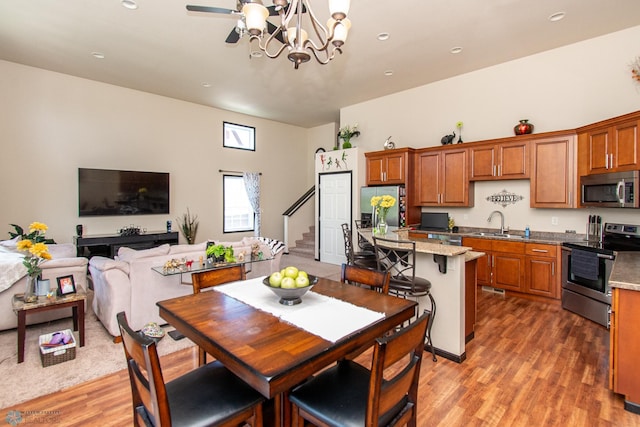 4110 Clubhouse Dr S, Fargo, ND 58104 - kitchen with stainless steel appliances, a sink, light wood-style flooring, a chandelier, and recessed lighting