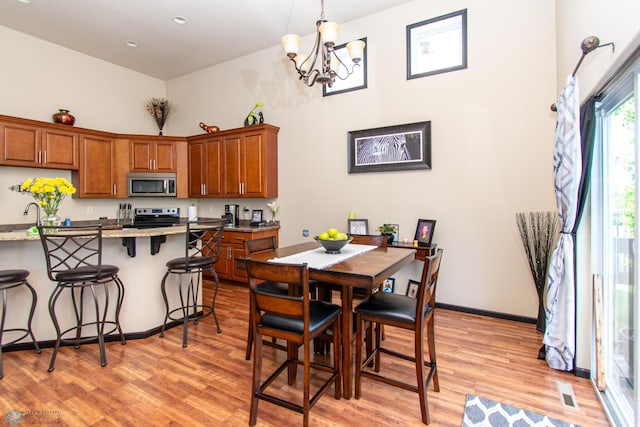 4110 Clubhouse Dr S, Fargo, ND 58104 - dining area featuring light wood-type flooring, a chandelier, a high ceiling, baseboards, and recessed lighting
