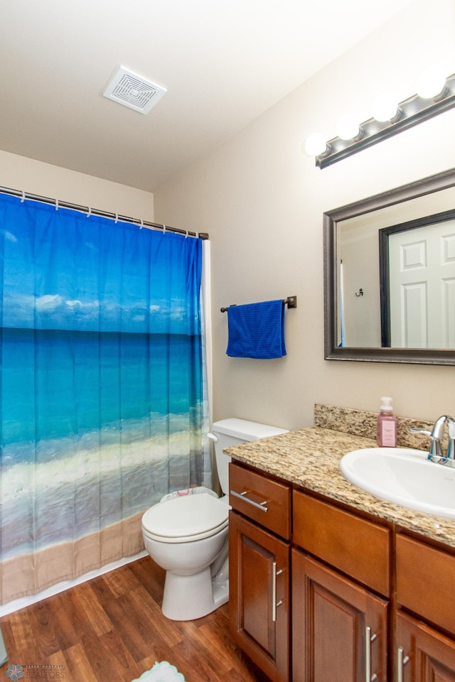 4110 Clubhouse Dr S, Fargo, ND 58104 - bathroom with vanity, toilet, wood finished floors, and curtained shower