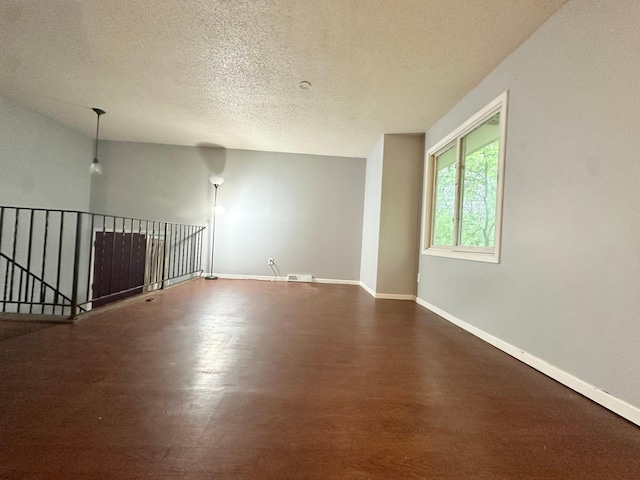 9329 Bass Creek Cir N, New Hope, MN 55428 - spare room featuring dark wood finished floors, a textured ceiling, and baseboards