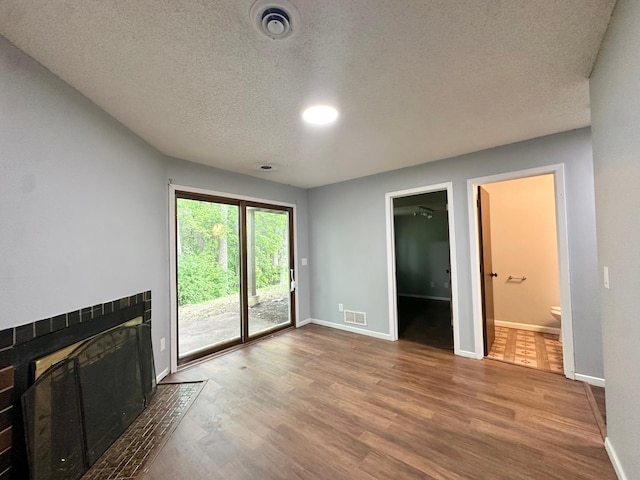 9329 Bass Creek Cir N, New Hope, MN 55428 - unfurnished living room featuring wood finished floors, baseboards, a textured ceiling, and a tile fireplace
