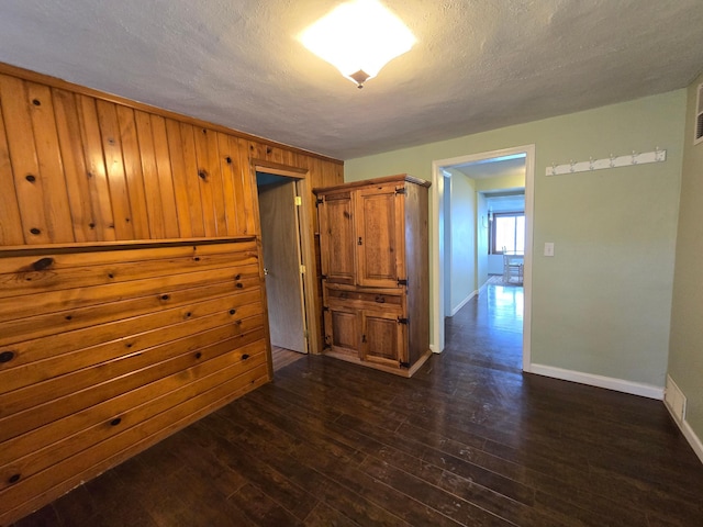 337 Lake Ave N, Spicer, MN 56288 - empty room with baseboards, dark wood finished floors, a textured ceiling, and wood walls