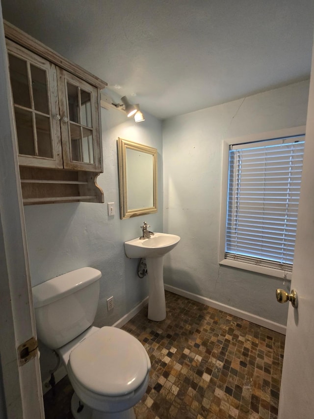 337 Lake Ave N, Spicer, MN 56288 - half bathroom featuring baseboards, toilet, and brick patterned floors