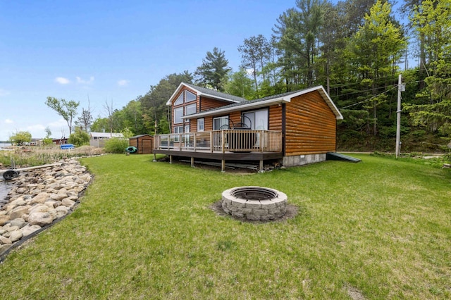 2648 Lake Shore Dr, Scandia Valley Twp, MN 56466 - rear view of property with faux log siding, an outdoor fire pit, a deck, a lawn, and crawl space