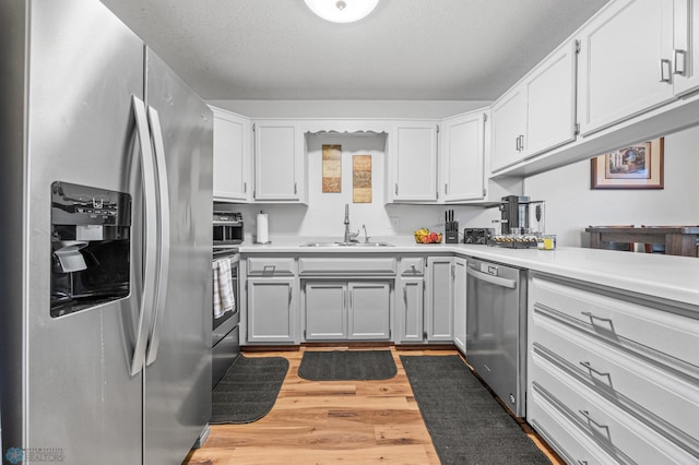 805 7th St NE, Dilworth, MN 56529 - kitchen featuring appliances with stainless steel finishes, a sink, light countertops, and light wood finished floors