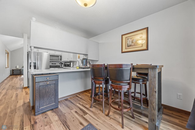 805 7th St NE, Dilworth, MN 56529 - bar area with stainless steel microwave, light wood finished floors, and baseboards