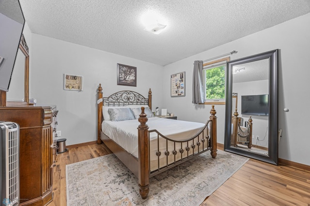 805 7th St NE, Dilworth, MN 56529 - bedroom with a textured ceiling, light wood-style floors, and baseboards