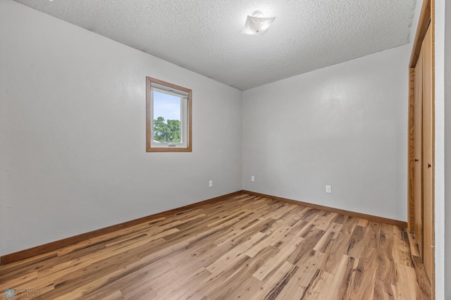 805 7th St NE, Dilworth, MN 56529 - empty room featuring light wood-style flooring, a textured ceiling, and baseboards