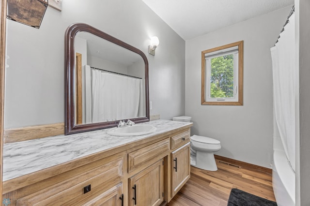 805 7th St NE, Dilworth, MN 56529 - bathroom featuring wood finished floors, vanity, toilet, baseboards, and curtained shower
