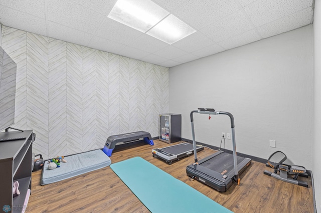 805 7th St NE, Dilworth, MN 56529 - exercise area featuring wallpapered walls, an accent wall, baseboards, wood finished floors, and a paneled ceiling
