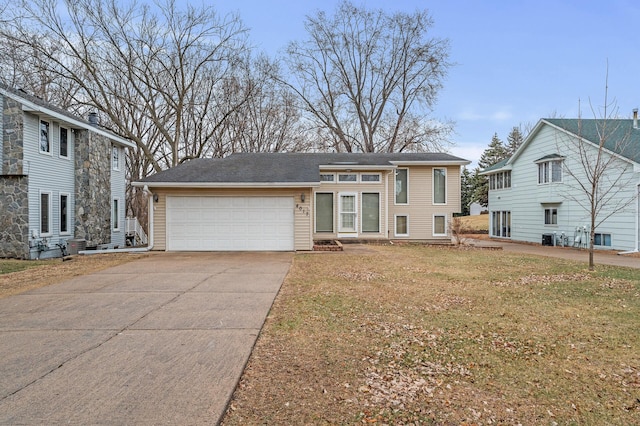 4017 Fordham Dr NE, Saint Anthony, MN 55421 - view of front of house with an attached garage, concrete driveway, a front lawn, and cooling unit