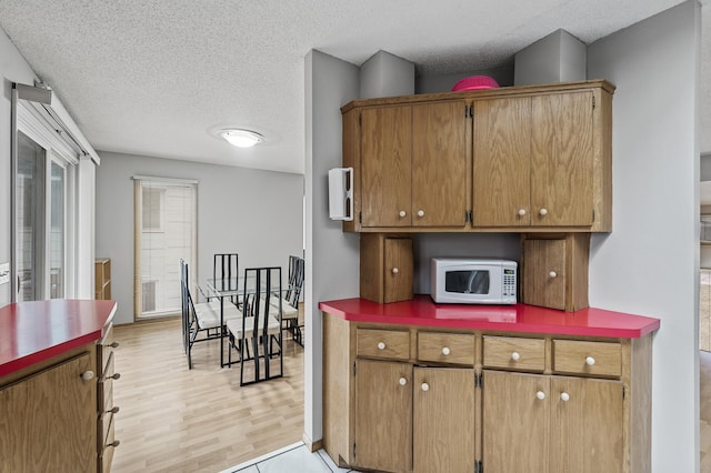 4017 Fordham Dr NE, Saint Anthony, MN 55421 - kitchen with white microwave, a textured ceiling, and light wood-type flooring