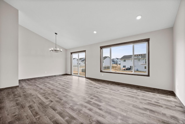 872 Watertown Ave, Delano, MN 55328 - empty room with lofted ceiling, a chandelier, wood finished floors, recessed lighting, and baseboards