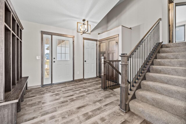 872 Watertown Ave, Delano, MN 55328 - entryway featuring a chandelier, light wood-type flooring, lofted ceiling, stairway, and a textured ceiling