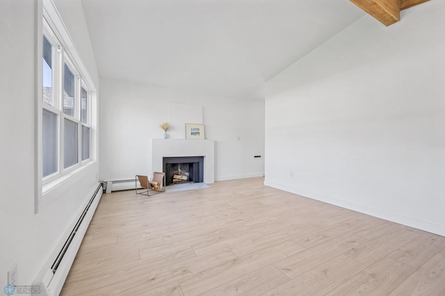 3017 8th St N, Fargo, ND 58102 - unfurnished living room featuring vaulted ceiling, a fireplace with flush hearth, light wood-style flooring, a baseboard heating unit, and baseboards